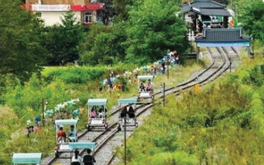 People are enjoying vehicles on train rails.