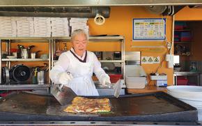A chef is cooking a huge pancake.