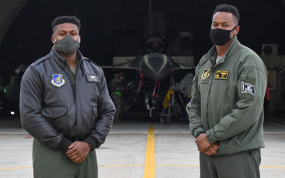 Maj. Douglas "Bane" Jenkins, 8th Fighter Wing Advanced Programs Office program manager, and Maj. Chris "Tuco" Harrison, 8th Fighter Squadron assistant director of operations and chief of standards and evaluations, pose for a photo in front of an F-16 Fighting Falcon on the flightline at Kunsan Air Base, Republic of Korea, Feb. 17, 2021. (U.S. Air Force photo by Senior Airman Suzie Plotnikov)