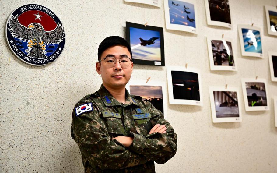 Republic of Korea Air Force Capt. Yo-Sep Lee, 38th Fighter Group Public Affairs Office chief, stands in front of a photo wall at Kunsan Air Base, ROK, Oct. 19, 2022. As public affairs chief, Lee helps maintain public relations, recreation events, documentation, and education at Kunsan AB. (U.S. Air Force Photo by Staff Sgt. Isaiah Soliz)