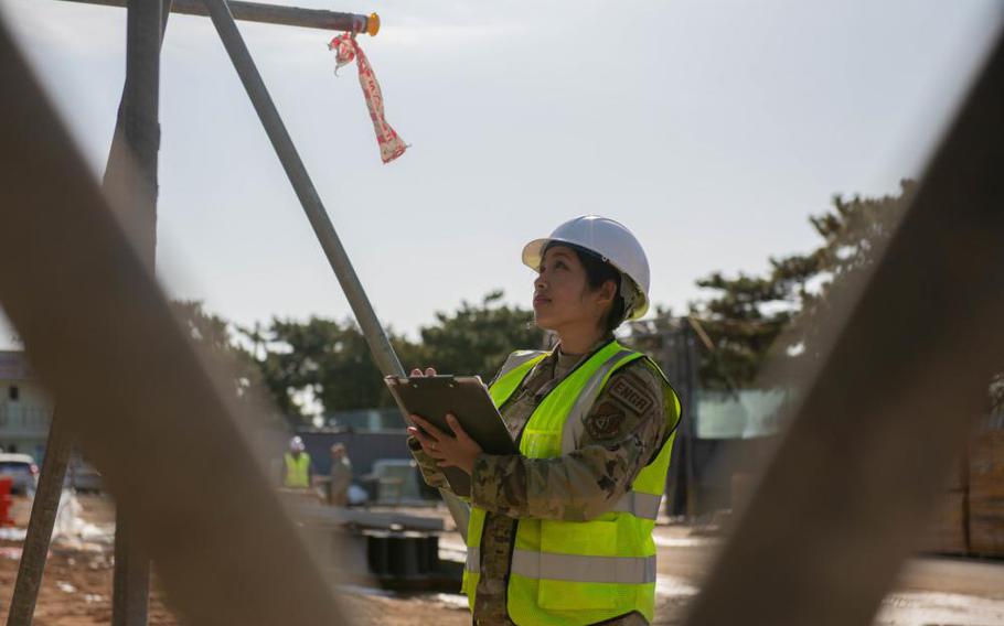 Staff Sgt. Elaine Olandez, 8th Civil Engineer Squadron construction manager, (right) consults with a construction worker on Kunsan Air Base, Republic of Korea, Dec. 15, 2022. Olandez also manages the wing’s Construction Escort Program where she coordinates the rotating schedule of Airmen who support the $300 million construction portfolio. (U.S. Air Force photo by 1st Lt. Cameron Silver)