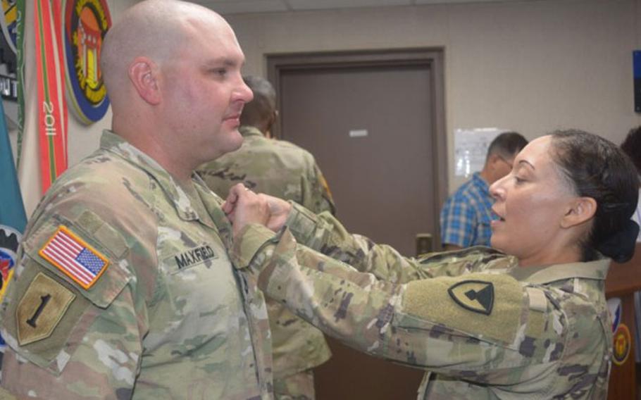 Col. Lisa Rennard, commander, 403rd Army Field Support Brigade, pins the Army Commendation Medal on Sgt. 1st Class Kristopher Maxfield, maintenance NCOIC, Support Operations, during an awards and promotion ceremony at brigade headquarters on Camp Henry, South Korea, Aug. 1. (Photo Credit: Galen Putnam)