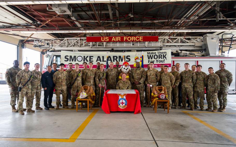 Col. Peter Kasarskis, 8th Fighter Wing commander, takes a photo with members of the 8th Civil Engineer Squadron fire department.