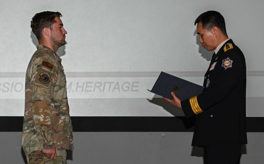 Yi, Jong-jun, right, Seoul Fire Department duty director, reads a letter of appreciation to U.S. Air Force Staff Sgt. Natanael Garcia, left, 8th Communications Squadron network system operations supervisor, during an 8th CS all call at Kunsan Air Base, Republic of Korea, Sept. 27, 2024.