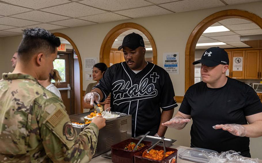 Capt. Carl Johnson, left, 8th Fighter Wing chaplain, and Staff Sgt. Jeffrey Higgins, 8th Operational Medical Readiness Squadron force health non-commissioned officer in charge, serve food during a Home Away From Home event at Kunsan Air Base, Republic of Korea, July 17, 2023. Home Away From Home events are held in the Son Light Inn with the 8th FW chapel team and volunteer units working together to provide Wolf Pack Airmen a home-cooked meal. (U.S. Air Force photo by Staff Sgt. Samuel Earick)