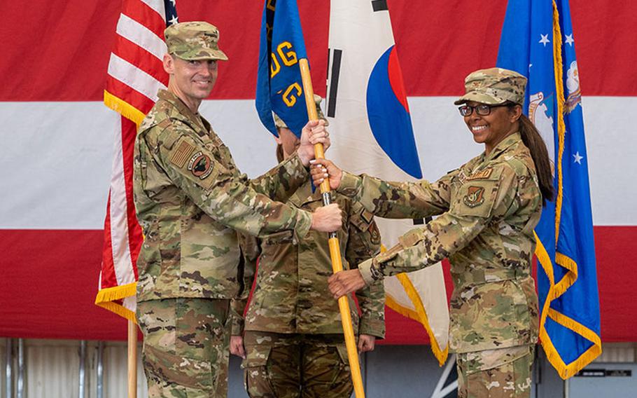 Col. Elizabeth Anderson-Doze, right, accepts command of the 8th Medical Group from Col. Timothy B. Murphy, 8th Fighter Wing commander, during the 8th MDG change of command ceremony at Kunsan Air Base, Republic of Korea, June 20, 2023. Anderson-Doze, 8th MDG incoming commander, assumed command of the 8th MDG from the outgoing commander, Col. Rene Saenz. (U.S. Air Force photo by Staff Sgt. Samuel Earick)