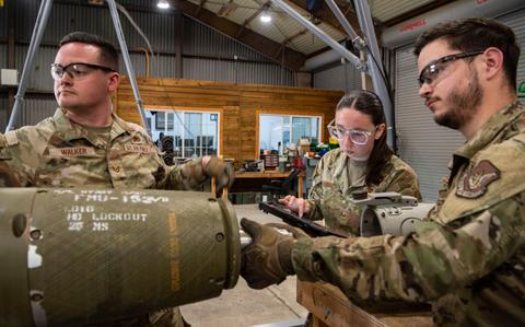 Photo Of U.S. Air Force Tech. Sgt. Joshua Walker, 51st Munitions Squadron conventional maintenance supervisor, left, and Airman 1st Class Niko Guaglianone, 51st MUNS conventional maintenance crew chief, assemble a munition while Senior Airman Quinn Corgiat, 51st MUNS conventional maintenance inspector reviews technical orders at Osan Air Base, Republic of Korea.
