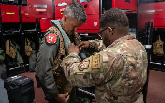 Photo Of U.S. Air Force Maj. Robert Oehmke, 104th Operations Group chief of standards and evaluations, gets assistance in putting on flight gear before an F-15C Eagle divestment flight and retirement at Kadena Air Base, Japan, Aug. 24, 2024.