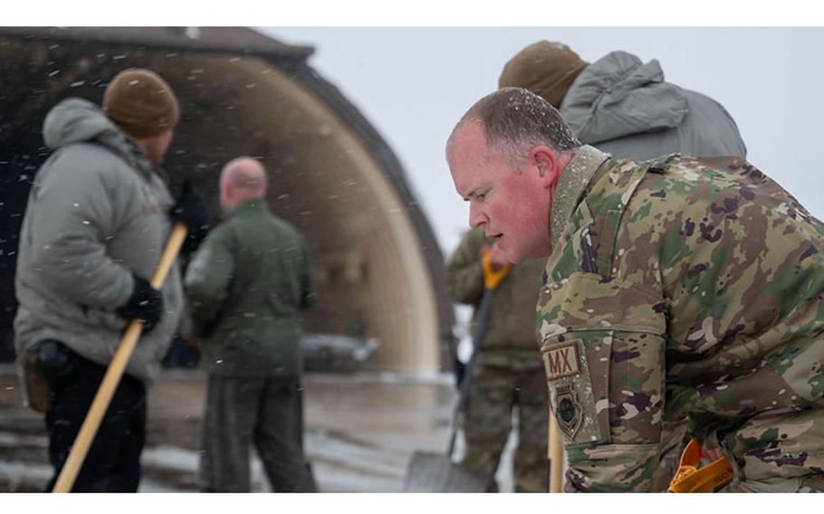 Chief Master Sgt. Scott Bradbury, 8th Maintenance Group senior enlisted leader, clears snow from an F-16 Fighting Falcon hangar alongside 35th Fighter Squadron Airmen at Kunsan Air Base, Republic of Korea, Dec. 20, 2023. Despite 10 inches of snowfall, Kunsan AB launched fighter jets to conduct a trilateral escort flight of U.S. bombers operating in the Indo-Pacific. (U.S. Air Force photo by Tech. Sgt. Emili Koonce)