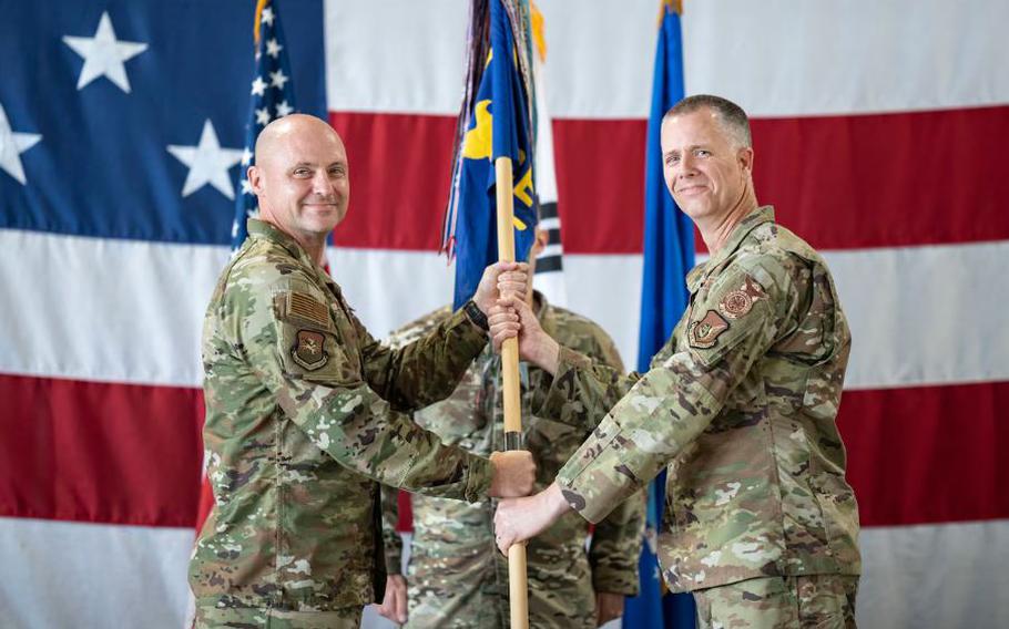 U.S. Air Force Col. Jeff Elliott, left, 51st Civil Engineering Group commander, passes the guidon to Lt. Col. Kirk Hull, incoming 51st Civil Engineer Squadron commander, during a Change of Command ceremony at Osan Air Base.