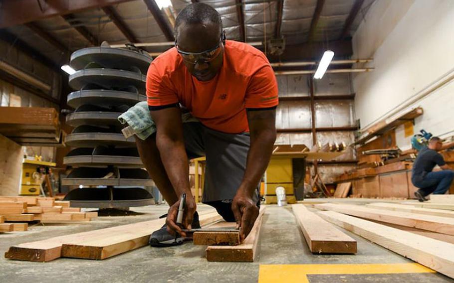 U.S. Air Force Tech Sgt. David Cameron, 8th Civil Engineer Squadron noncommissioned officer in charge of the fuels lab craft, measures refurbished wood planks at Kunsan Air Base, Republic of Korea, Aug 28, 2021. Volunteers from across the Wolf Pack dedicated hours of woodworking, gardening, painting and more to ensure the Kunsan Air Base Legacy Garden was built and dedicated to veterans by Sept 8, 2021. (U.S. Air Force photo by Staff Sgt. Jesenia Landaverde)