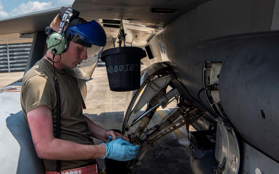 Senior Airman Sean Wehner, 36th Fighter Generation Squadron aerospace propulsion journeyman, puts on gloves before draining hydraulic fluid from an A-10C Thunderbolt II during a training sortie at Gwangju Air Base, Republic of Korea, Aug. 18, 2022. Deployed to Gwangju for the week, the Airmen trained and performed different jobs to become multi-capable Airmen as part of the U.S Air Force’s Agile Combat Employment concept. (U.S. Air Force photo by Staff Sgt. Dwane R. Young)