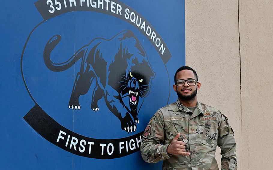 Staff Sgt. Lixandy Estrella Cespedes stands beside his squadrons logo at Kunsan Air Base, Republic of Korea, Mar. 17, 2023. While getting in-processed, Estrella Cespedes was able to fix the records of 15 members and out-processed two more, hitting the ground running after his arrival. (U.S. Air Force photo by 1st Lt. Cameron Silver)