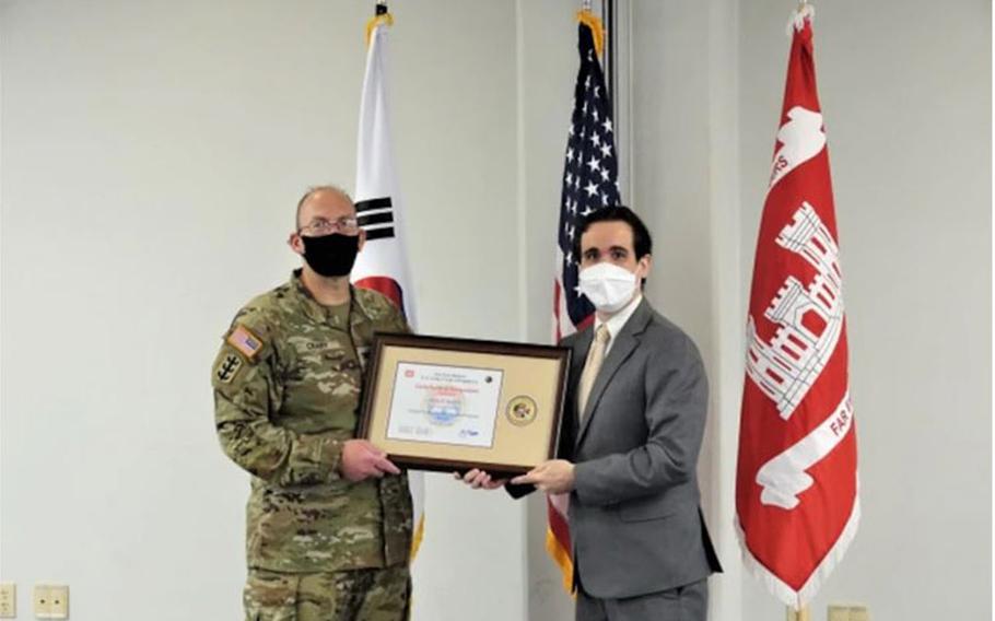 Dennis Headrick receives a certificate of recognition from Far East District Commander, Col. Christopher Crary, during graduation from the U.S. Army Corps of Engineers Leadership Development Program Level 2, July 19, 2021.