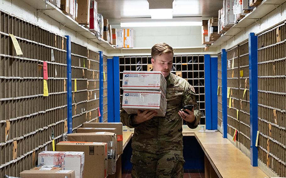 Staff Sgt. Devin Dunlap, 8th Force Support Squadron registered mail NCO in charge, grabs two packages at Kunsan Air Base, Republic of Korea, Nov. 26, 2022. During their holiday operations, the post office receives around 200 parcels weekly and sometimes more; almost three times its usual intake. (U.S. Air Force photo by Staff Sgt. Sadie Colbert)