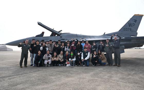 Photo Of 8th Fighter Wing Airmen pose for a photo with students from Kunsan National University in front of a U.S. Air Force F-16 Fighting Falcon aircraft at Kunsan Air Base, Republic of Korea.