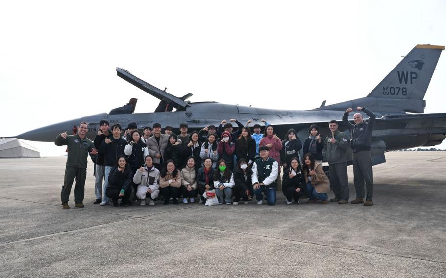 8th Fighter Wing Airmen pose for a photo with students from Kunsan National University in front of a U.S. Air Force F-16 Fighting Falcon aircraft at Kunsan Air Base, Republic of Korea.