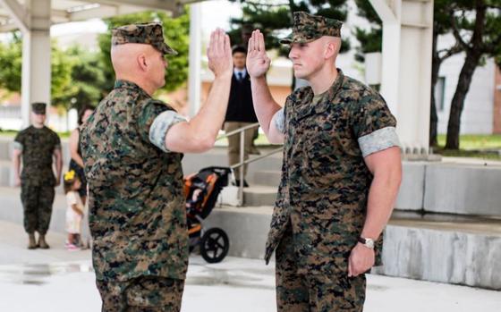U.S. Marine Corps Staff Sgt. Jonathan Hemme, right, a career planner with U.S. Marine Corps Forces, Korea recites the oath of enlistment to Major Gen. W. “Wes” E. Souza III, Commander, U.S. Marine Corps Forces, Korea during an award and reenlistment ceremony on U.S. Army Garrison Camp Humphreys, South Korea, July 17, 2024.
