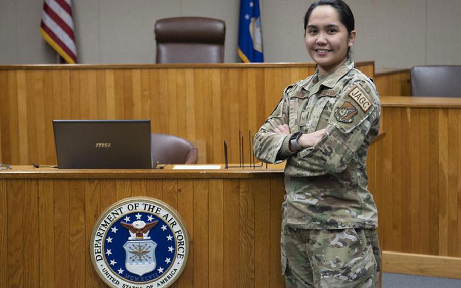 Senior Airman Issey Jeorgina Silva, 8th Fighter Wing judge advocate military justice paralegal, smiles for a photo in a courtroom at Kunsan Air Base, Republic of Korea, Jan. 19, 2023. Silva was named Pride of the Pack for her innovative thinking in creating a useful JA reporting tool used during a busy holiday season. (U.S. Air Force photo by Staff Sgt. Isaiah J. Soliz)