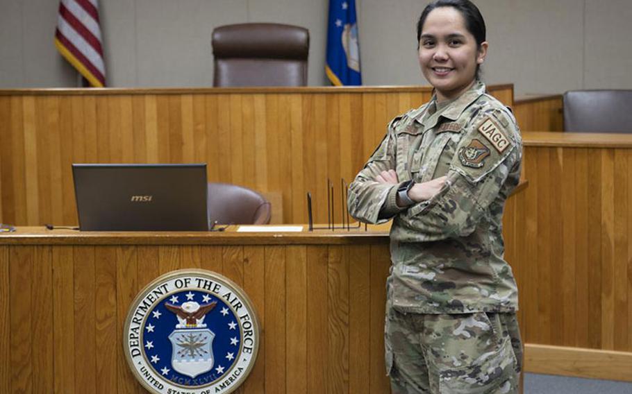 Senior Airman Issey Jeorgina Silva, 8th Fighter Wing judge advocate military justice paralegal, smiles for a photo in a courtroom at Kunsan Air Base, Republic of Korea, Jan. 19, 2023. Silva was named Pride of the Pack for her innovative thinking in creating a useful JA reporting tool used during a busy holiday season. (U.S. Air Force photo by Staff Sgt. Isaiah J. Soliz)