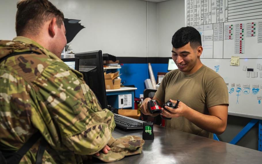 Senior Airman Pedro Garay, 35th Fighter Generation Squadron crew chief, issues equipment to Airman Dante Shaver, 35th FGS weapons load crew, at Kunsan Air Base, Republic of Korea, Oct. 2, 2024.