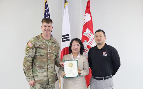 Photo Of Song Mi, Management Analyst with the Resource Management Office of the U.S. Army Corps of Engineers – Far East District, earns a 45-year service award presented by Col. Jeremiah J. Willis, Commander, and David Chai, Deputy District Engineer.