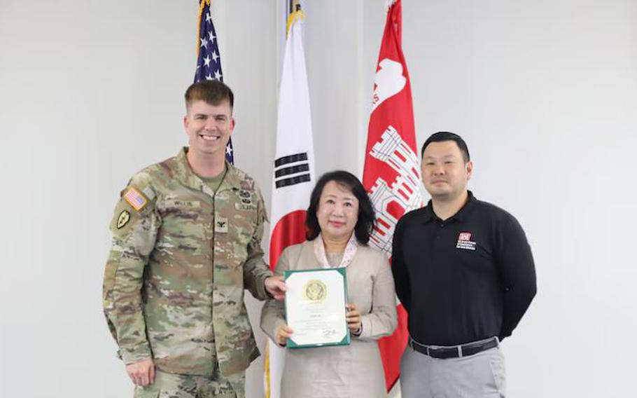 Song Mi, Management Analyst with the Resource Management Office of the U.S. Army Corps of Engineers – Far East District, earns a 45-year service award presented by Col. Jeremiah J. Willis, Commander, and David Chai, Deputy District Engineer.