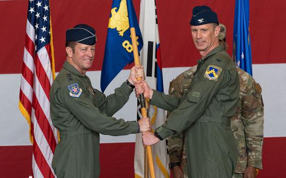 U.S. Air Force Lt. Gen. David Iverson, left, 7th Air Force commander, presents the 8th Fighter Wing guidon to Col. Peter Kasarskis, 8th FW incoming commander, during the 8th FW change of command ceremony at Kunsan Air Base, Republic of Korea, June 7, 2024.