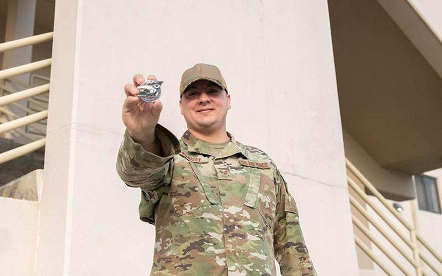 Staff Sgt. Nathan Wemhoff, 8th Healthcare Operations Squadron NCOIC of ambulance services, holds up a wing commander's challenge coin at Kunsan Air Base, Republic of Korea, Jan. 5, 2023. Wemhoff leads a team of 12 members, overseeing emergency medical response for the entire base. (U.S. Air Force photo by 1st Lt. Cameron Silver)