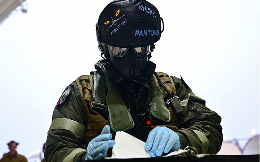 First Lt. Moritz Wienke, 35th Fighter Squadron pilot, performs a preflight check while outfitted in chemical, biological, radiological and nuclear protective equipment at Kunsan Air Base, South Korea, Jan. 13, 2023. Pacific Air Forces sent a validation team to Kunsan AB in the first step of a PACAF-wide Next Generation Aircrew Protection program update. (U.S. Air Force photo by Staff Sgt. Isaiah J. Soliz)