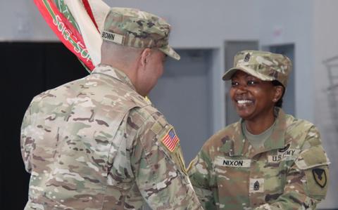 Photo Of Col. Henry C. Brown, commander, 403rd Army Field Support Brigade, passes the unit colors to Command Sgt. Maj. TaJuana S. Nixon, incoming brigade command sergeant major, during the Powerhouse Brigade’s change of responsibility ceremony at Camp Walker, South Korea.