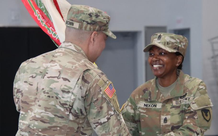 Col. Henry C. Brown, commander, 403rd Army Field Support Brigade, passes the unit colors to Command Sgt. Maj. TaJuana S. Nixon, incoming brigade command sergeant major.
