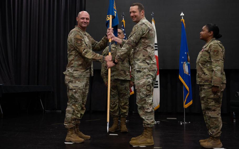U.S. Air Force Col. Jeff Elliott, left, 51st Mission Support Group commander, passes the guidon to Lt. Col. Edmund Ward, right, incoming 51st Force Support Squadron commander, during a Change of Command ceremony at Osan Air Base, Republic of Korea.