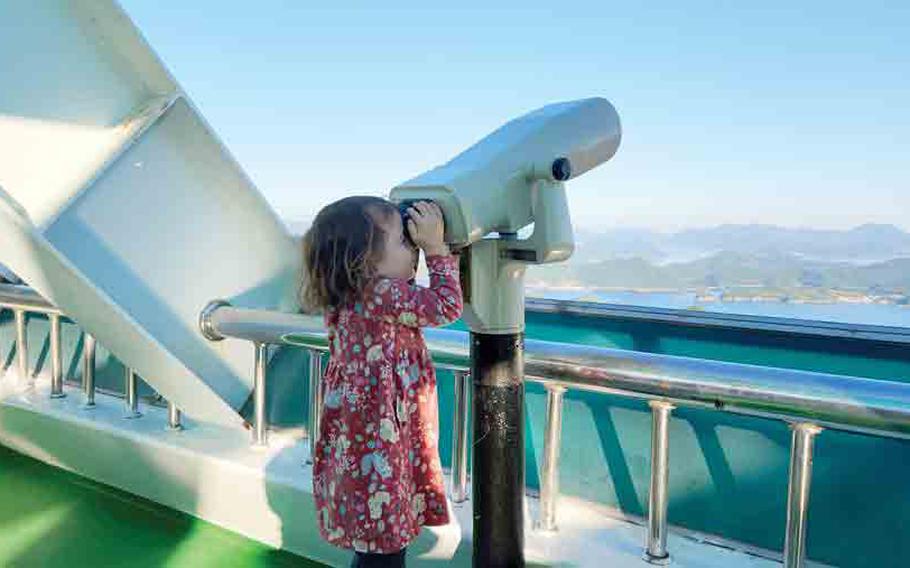 a little child and telescope at observation deck