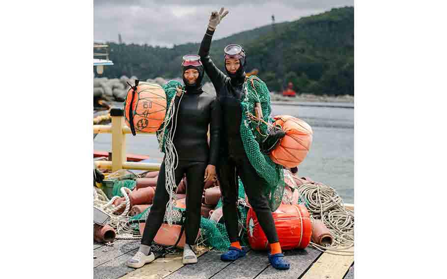 two haenyeoes (sea women, female divers) posing for a photo