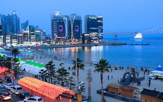 Gwangalli Beach with buildings and a bridge at night.